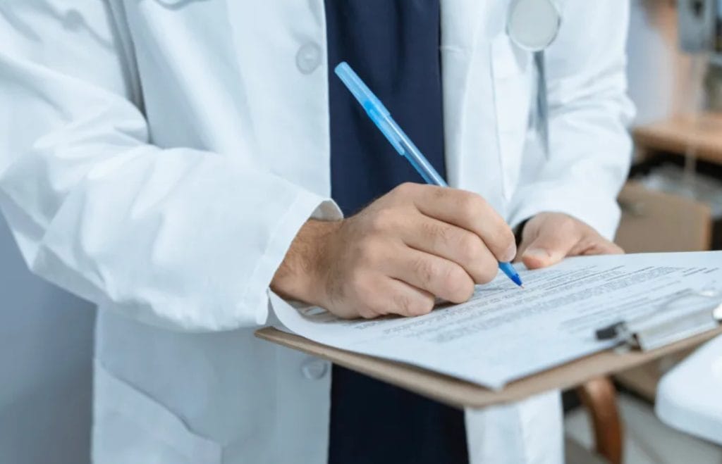 Doctor completing patient documentation during a skin cancer consultation, emphasizing early detection and personalized care for melanoma, BCC, and SCC.